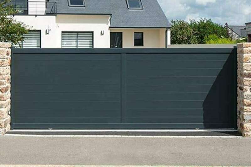 Portail coulissant en aluminium anthracite devant une maison bretonne